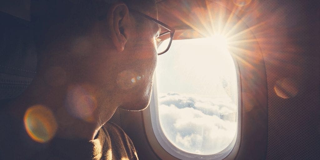 man looking out plane window